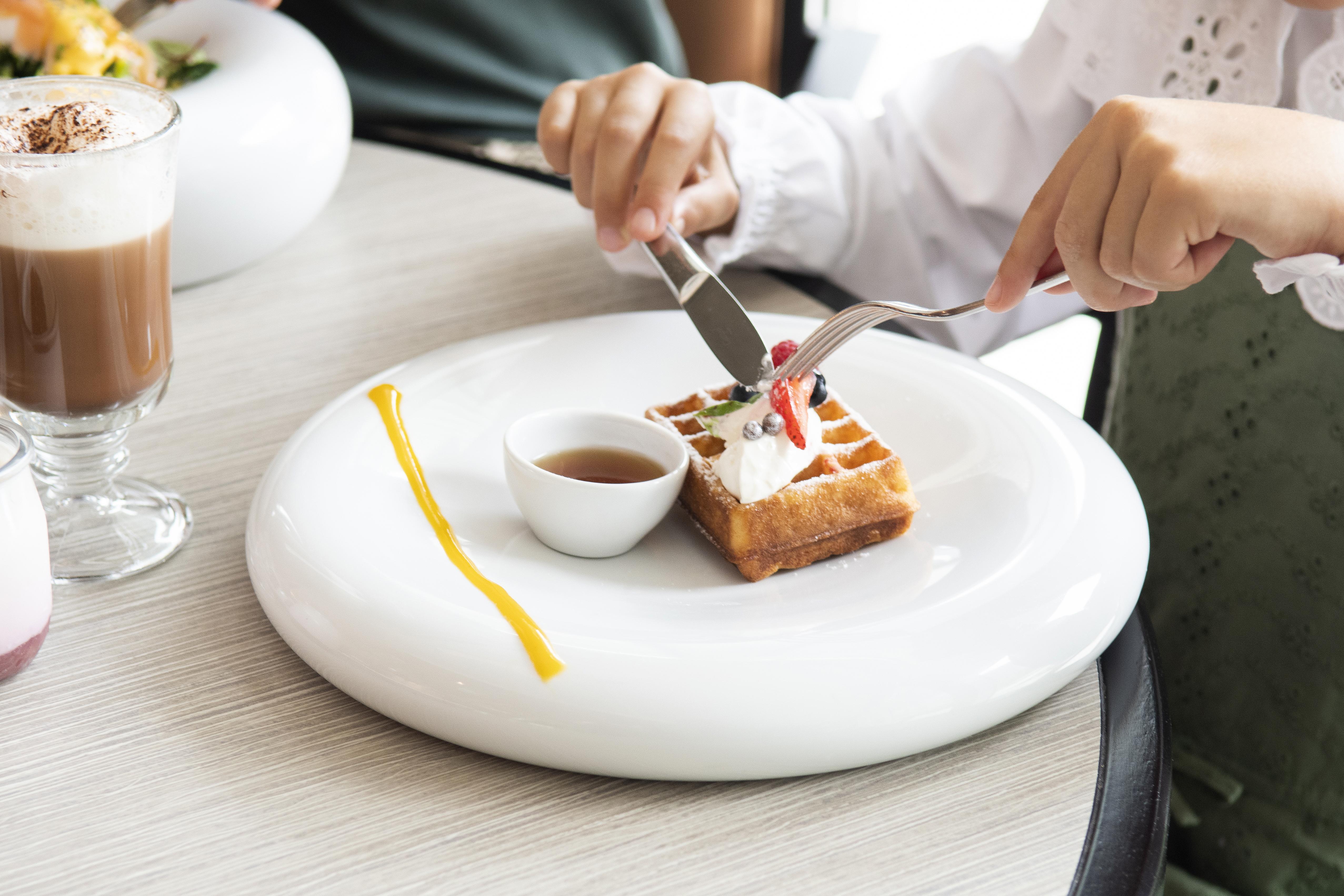 โรงแรมอีปิก ซานา ลิสบัว ลิสบอน ภายนอก รูปภาพ A woman using a knife and fork to cut a dessert